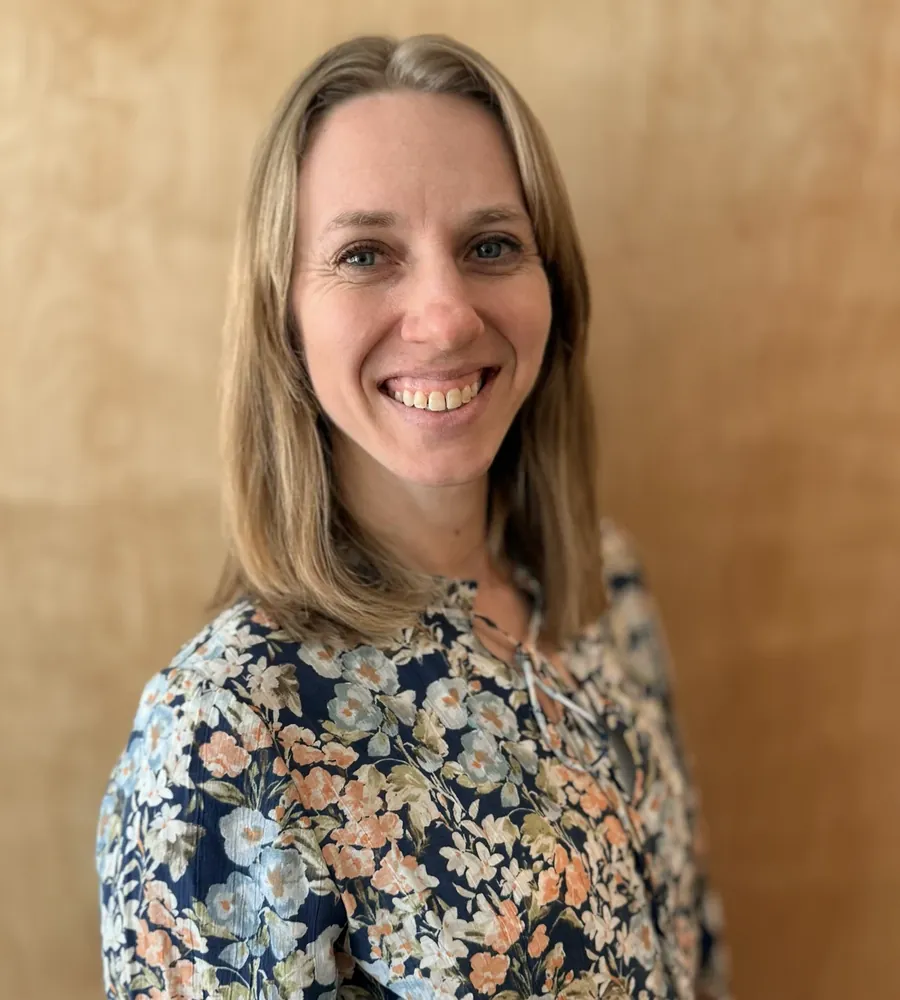 Paige Gore, smiling, in a floral blouse