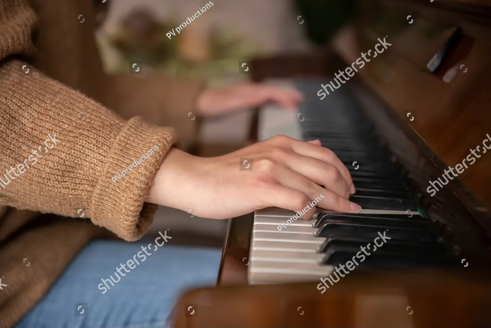 Hands resting on the keys of a piano