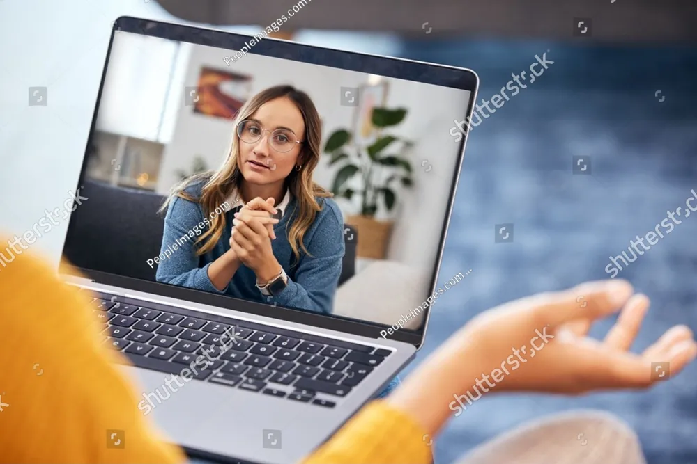 A therapist on a video call, seen on a laptop screen