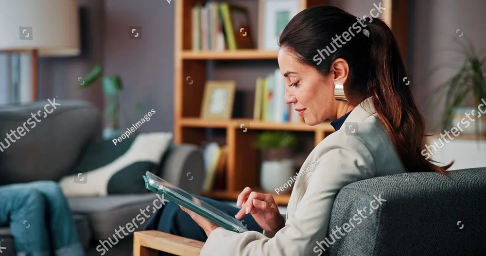 A woman in a cosy room making notes on a tablet