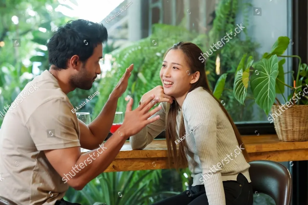 A man and a woman talking at a cafe table